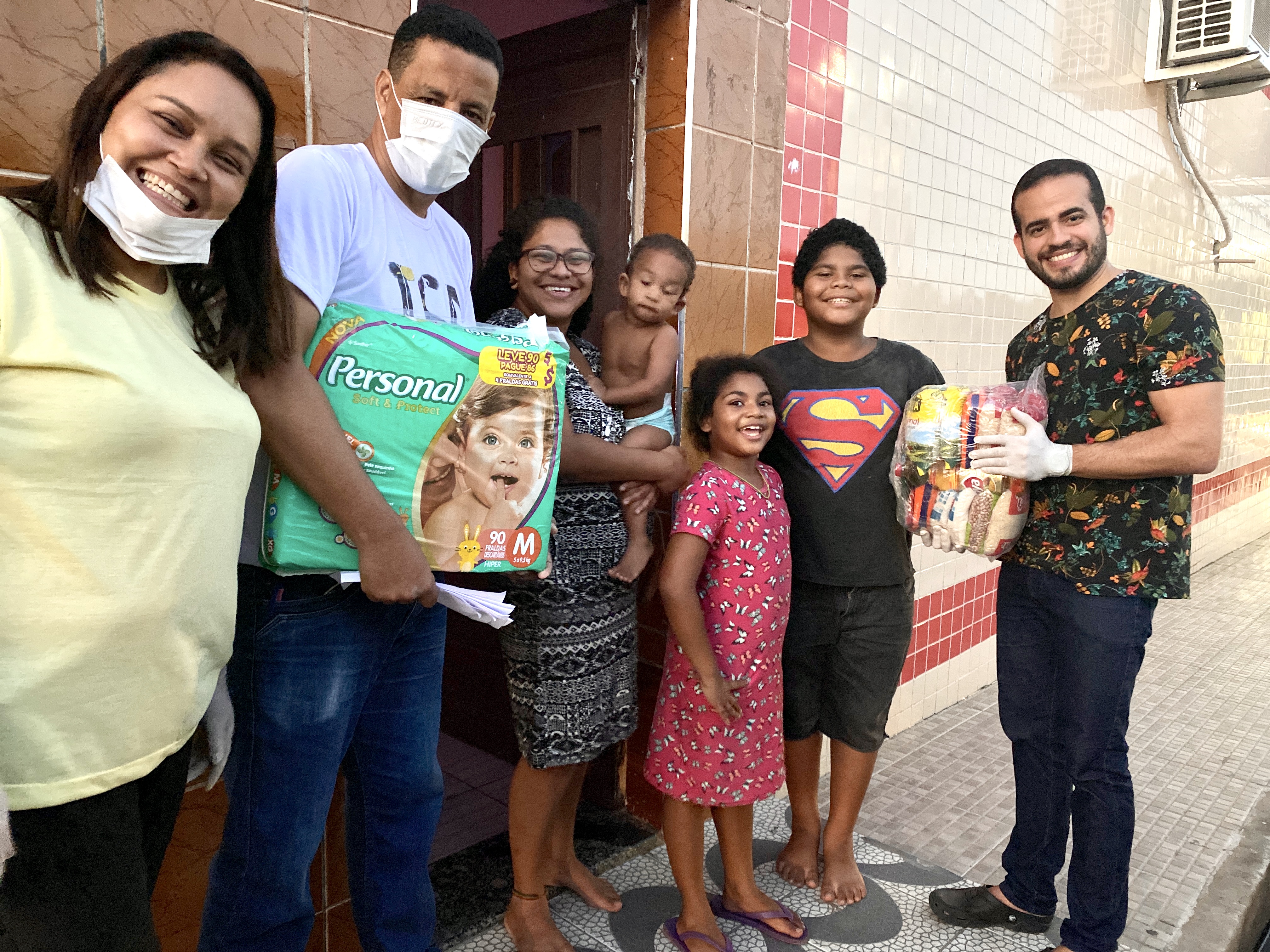 Equipe e família durante uma ação de entrega de doações